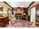 Cozy living room featuring paneled walls, fireplace, built-in shelving, and wood shutters for ample natural light at 3456 Paces Nw Pl, Atlanta, GA 30327