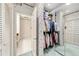 Open walk-in closet with racks of clothes, a view into a bathroom and patterned wall paper at 3456 Paces Nw Pl, Atlanta, GA 30327