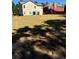 Large backyard featuring grassy lawn, mature trees, and two-story home exterior at 457 Panhandle Pl, Hampton, GA 30228