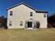 Home exterior with spacious backyard featuring a grassy lawn and outdoor grilling area at 457 Panhandle Pl, Hampton, GA 30228