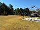 Large backyard with a manicured lawn, mature trees, fence, and outdoor grill at 457 Panhandle Pl, Hampton, GA 30228