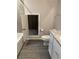 Bathroom featuring gray tile, wood-look floors, and access to storage area at 457 Panhandle Pl, Hampton, GA 30228