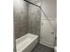 Bathroom featuring gray tile and a white bathtub and white door to storage area at 457 Panhandle Pl, Hampton, GA 30228