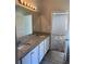Well-lit bathroom with double sinks, granite counters, and access to the bedroom, combining style and functionality at 457 Panhandle Pl, Hampton, GA 30228