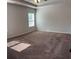 Spacious bedroom with tray ceiling, a window, and plush carpet, creating a serene and inviting atmosphere at 457 Panhandle Pl, Hampton, GA 30228