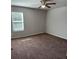 Neutral bedroom with ceiling fan, window, and plush brown carpet at 457 Panhandle Pl, Hampton, GA 30228
