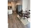 This dining area boasts wood floors, a cozy rug, and a round table, adjacent to the kitchen with white cabinets at 457 Panhandle Pl, Hampton, GA 30228