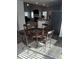 Open-concept dining area with a round table, visible kitchen, and living space with fireplace, all on hardwood floors at 457 Panhandle Pl, Hampton, GA 30228