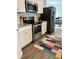 The kitchen has stainless steel appliances, granite countertops, and colorful rug at 457 Panhandle Pl, Hampton, GA 30228