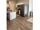 Modern kitchen with stainless steel appliances, white cabinetry, granite countertops, and wood-look flooring at 457 Panhandle Pl, Hampton, GA 30228