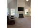 Bright living room with high ceilings, fireplace, fan, plush carpet, and abundant natural light at 457 Panhandle Pl, Hampton, GA 30228