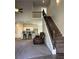 Bright living area featuring an open layout to kitchen, stairs with decorative metal railing, and hardwood floors at 457 Panhandle Pl, Hampton, GA 30228