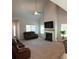 Bright living room with high ceilings, fireplace, fan, plush carpet, and abundant natural light at 457 Panhandle Pl, Hampton, GA 30228