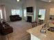 The open-concept living room features high ceilings, fireplace, and two leather sofas at 457 Panhandle Pl, Hampton, GA 30228