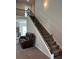 Spacious living room features carpeted stairs with decorative railing, and comfortable seating at 457 Panhandle Pl, Hampton, GA 30228