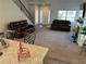 The open-concept living room features stairs, fireplace, and two leather sofas at 457 Panhandle Pl, Hampton, GA 30228