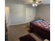 Spacious carpeted main bedroom with ceiling fan and dark wood furnishings at 457 Panhandle Pl, Hampton, GA 30228