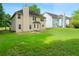 A large, grassy backyard with a beige two-story house with a chimney at 237 River Pass Ct, Dacula, GA 30019