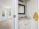 Half bathroom with white vanity and decorative mirror; tile floors visible in adjacent dining area at 237 River Pass Ct, Dacula, GA 30019