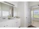Bright bathroom featuring double sinks, white cabinets, and a large mirror at 237 River Pass Ct, Dacula, GA 30019