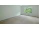 This bedroom has a neutral carpet, and white walls, with a window that brings in natural light at 237 River Pass Ct, Dacula, GA 30019
