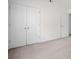 This bright bedroom features doors for closet space and plush carpeting at 237 River Pass Ct, Dacula, GA 30019