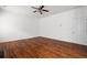 Large bedroom with hardwood floors, a ceiling fan, and a door at 237 River Pass Ct, Dacula, GA 30019