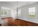 Inviting dining room with hardwood floors, chandelier, wainscoting, and abundant natural light at 237 River Pass Ct, Dacula, GA 30019