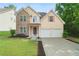 Charming two-story home featuring a stone facade, two-car garage, and well-manicured lawn at 237 River Pass Ct, Dacula, GA 30019