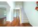 Bright and airy foyer with hardwood floors, staircase, and views into the dining room and kitchen at 237 River Pass Ct, Dacula, GA 30019