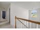 Upstairs hallway with carpet, white walls, and a view of the front door and window at 237 River Pass Ct, Dacula, GA 30019