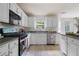 Bright kitchen showcasing white cabinets, stainless steel appliances, and a neutral tile floor at 237 River Pass Ct, Dacula, GA 30019