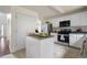Well-lit kitchen features white cabinets, stainless steel appliances, and an island at 237 River Pass Ct, Dacula, GA 30019