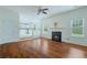 Open-concept living room with hardwood floors, fireplace, and view into the kitchen at 237 River Pass Ct, Dacula, GA 30019