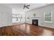 Spacious living room with hardwood floors, a fireplace, and an open view to the kitchen and dining area at 237 River Pass Ct, Dacula, GA 30019