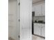 View of pantry with wire shelving and folding door, next to the kitchen's white cabinets and countertop at 237 River Pass Ct, Dacula, GA 30019