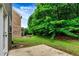 Green backyard and patio area with privacy fence and mature trees on a sunny day at 3153 Daleview Sw Way, Atlanta, GA 30331