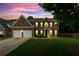 Beautiful two-story brick home at twilight featuring a lush lawn and three-car garage at 3153 Daleview Sw Way, Atlanta, GA 30331