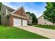 View of the home's three-car garage, driveway and well-manicured front lawn at 3153 Daleview Sw Way, Atlanta, GA 30331