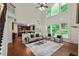 Open-concept living room with hardwood floors, two-story windows, and access to the kitchen at 3153 Daleview Sw Way, Atlanta, GA 30331