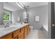 Bright bathroom featuring double sinks, wood cabinets, and a large mirror at 411 Sugar Maple Ct, Canton, GA 30114