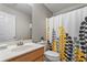 Bathroom with a floral shower curtain, single sink and neutral decor at 411 Sugar Maple Ct, Canton, GA 30114