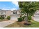 Two-story home with a two-car garage, manicured landscaping, and shade tree at 411 Sugar Maple Ct, Canton, GA 30114