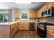 Well-lit kitchen featuring stainless steel appliances, light wood cabinetry, and a tiled backsplash at 411 Sugar Maple Ct, Canton, GA 30114