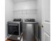 A modern laundry room featuring a stacked washer and dryer and wire rack shelving for efficient organization at 411 Sugar Maple Ct, Canton, GA 30114