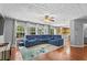 Spacious living room with hardwood floors, large windows, and a cozy blue sectional at 411 Sugar Maple Ct, Canton, GA 30114