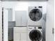 Laundry room featuring a stacked washer and dryer with white cabinets and utility sink at 560 Dutch Valley Ne Rd # 2207, Atlanta, GA 30324