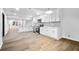 Open-concept kitchen with white cabinets, modern appliances, and adjacent living space at 3144 Corner Oak Dr, Norcross, GA 30071