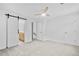Spacious bedroom with neutral carpet, barn door to ensuite bathroom, and ceiling fan at 3144 Corner Oak Dr, Norcross, GA 30071