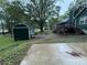 Backyard features a shed, adjacent patio, mature trees and rear view of surrounding homes at 608 Fairhaven Blvd, Stockbridge, GA 30281